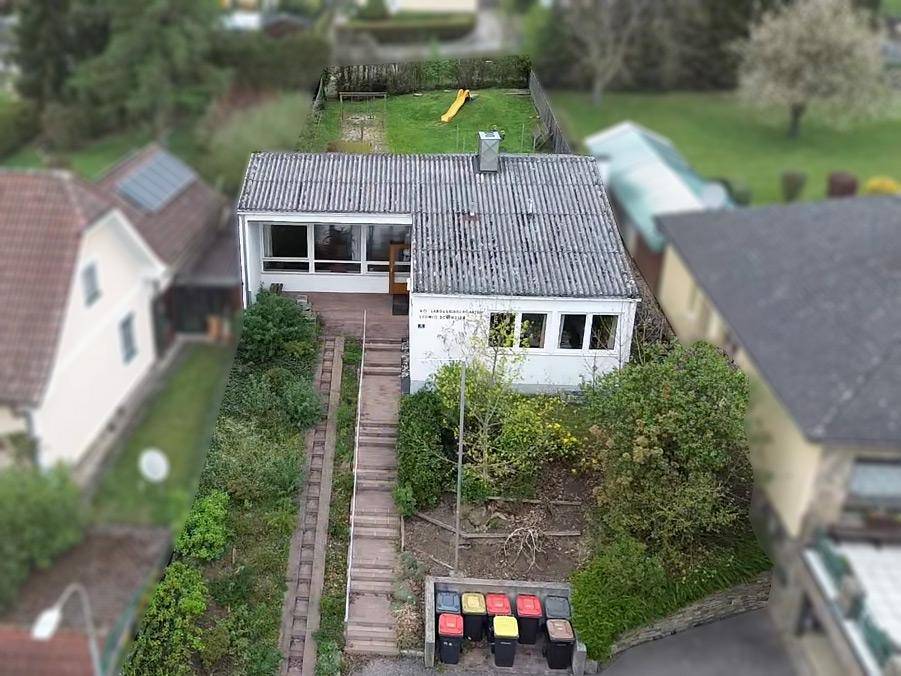 Übersicht des Anwesens von oben mit Garten, Zufahrt und angrenzenden Häusern in ländlicher Umgebung.