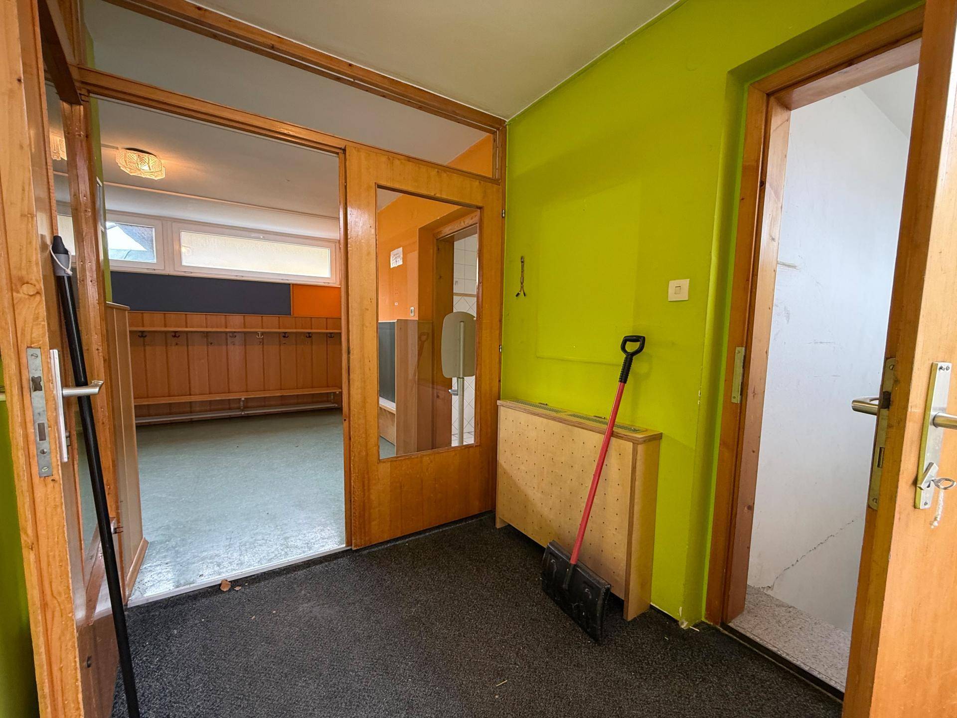 Eingangsbereich mit Garderobe, bunten Wänden und Zugang zu weiteren Räumen des Gebäudes.