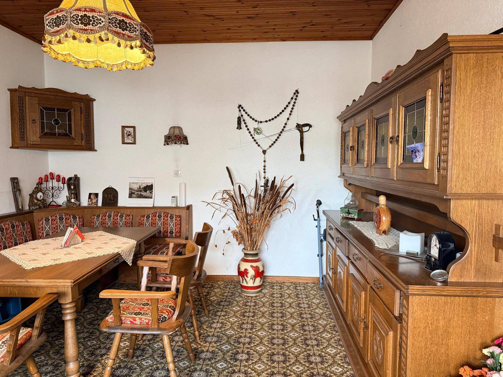 Esszimmer im traditionellen Stil mit Holztisch, Eckbank und gemustertem Teppichboden.