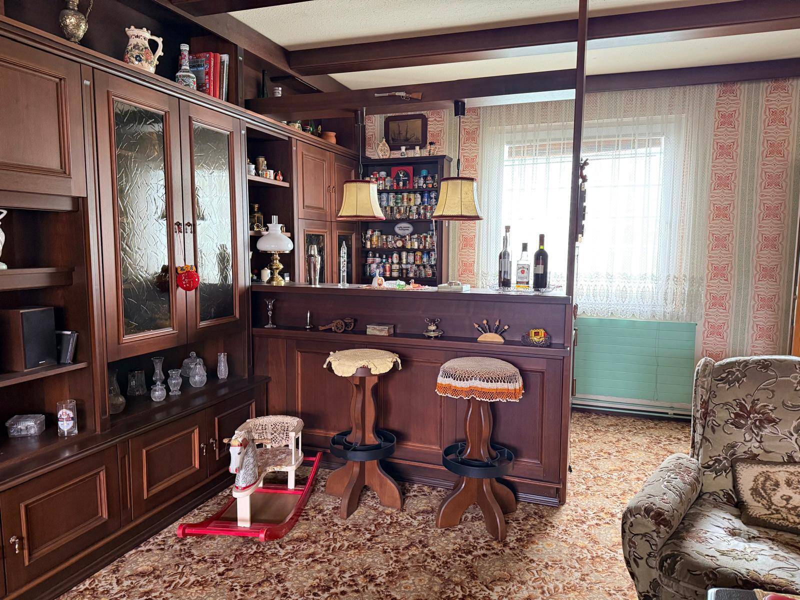 Gemütliches Wohnzimmer im traditionellen Stil mit Hausbar und dunklen Holzmöbeln.