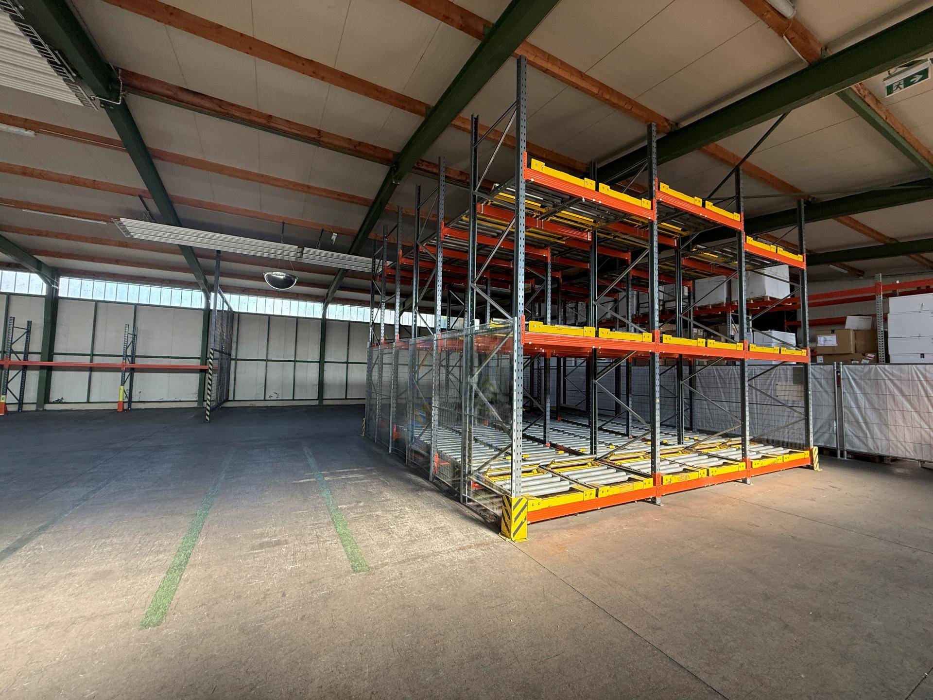 Weitläufige Lagerhalle mit robusten Regalsystemen und Betonboden, ideal für industrielle Nutzung.