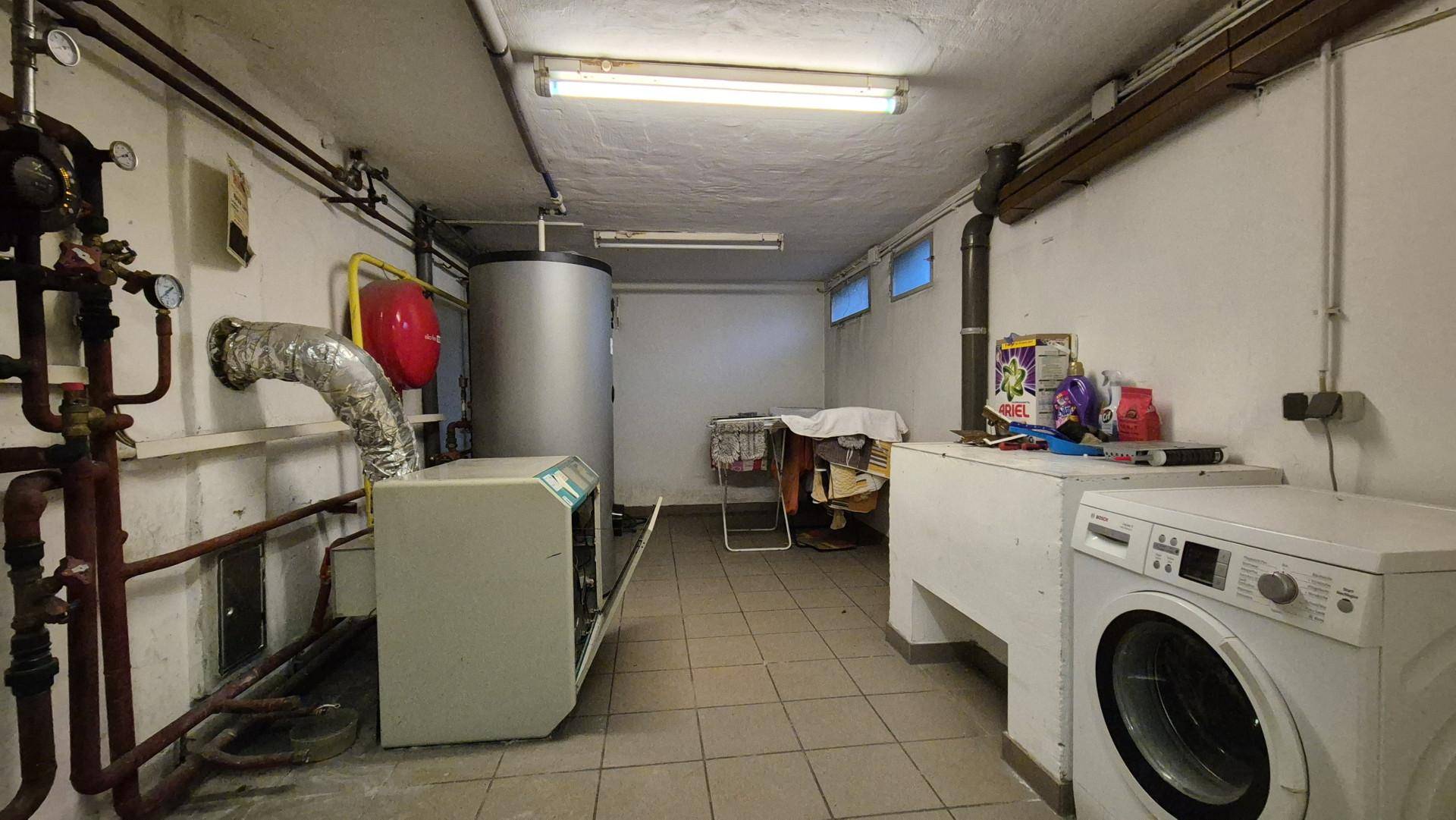Hauswirtschaftsraum im Keller mit Waschmaschine, Boiler und Heizungsanlage.