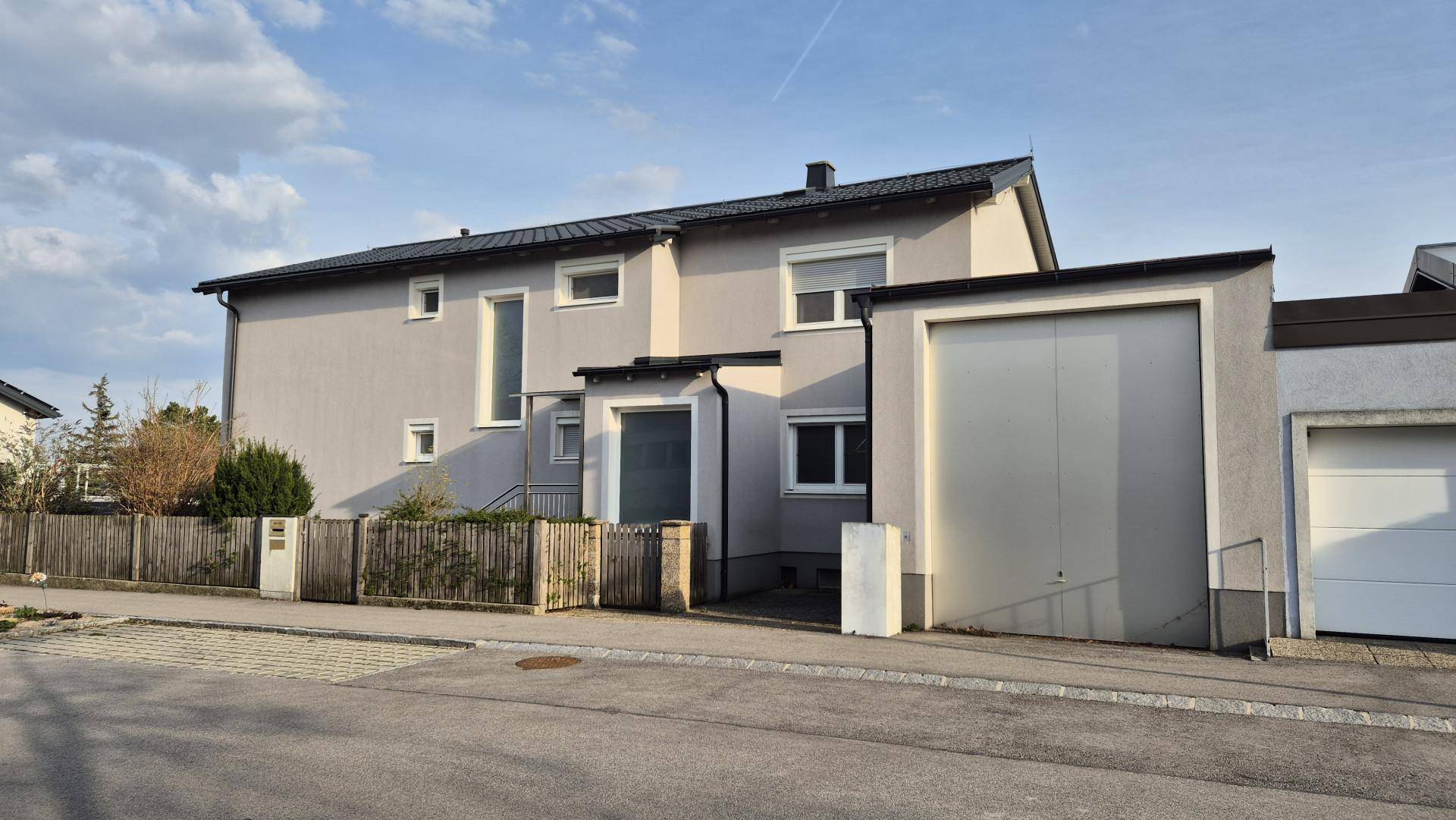 Ansicht des Wohnhauses mit integrierter Garage und moderner Fassade.
