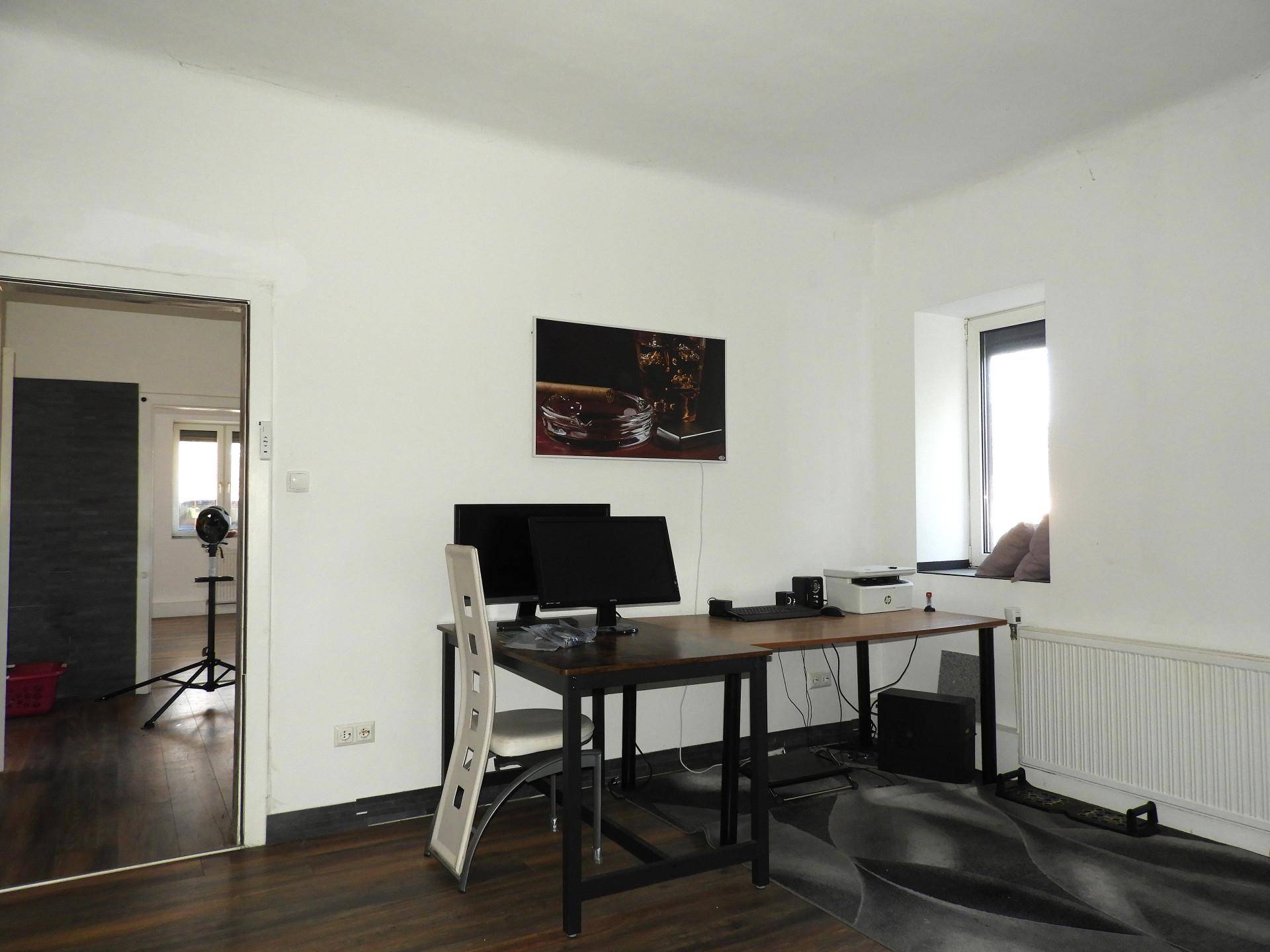 Arbeitszimmer mit Schreibtisch, zwei Monitoren und Holzboden.