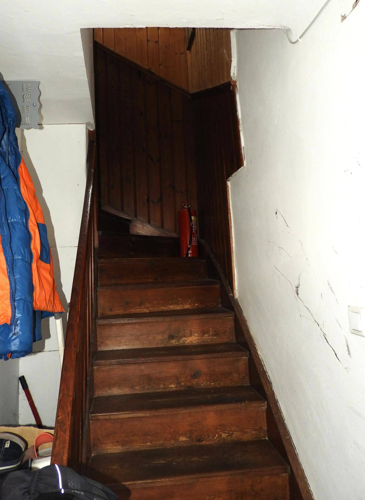 Holztreppe führt in ein Obergeschoss, umgeben von Holzverkleidung.