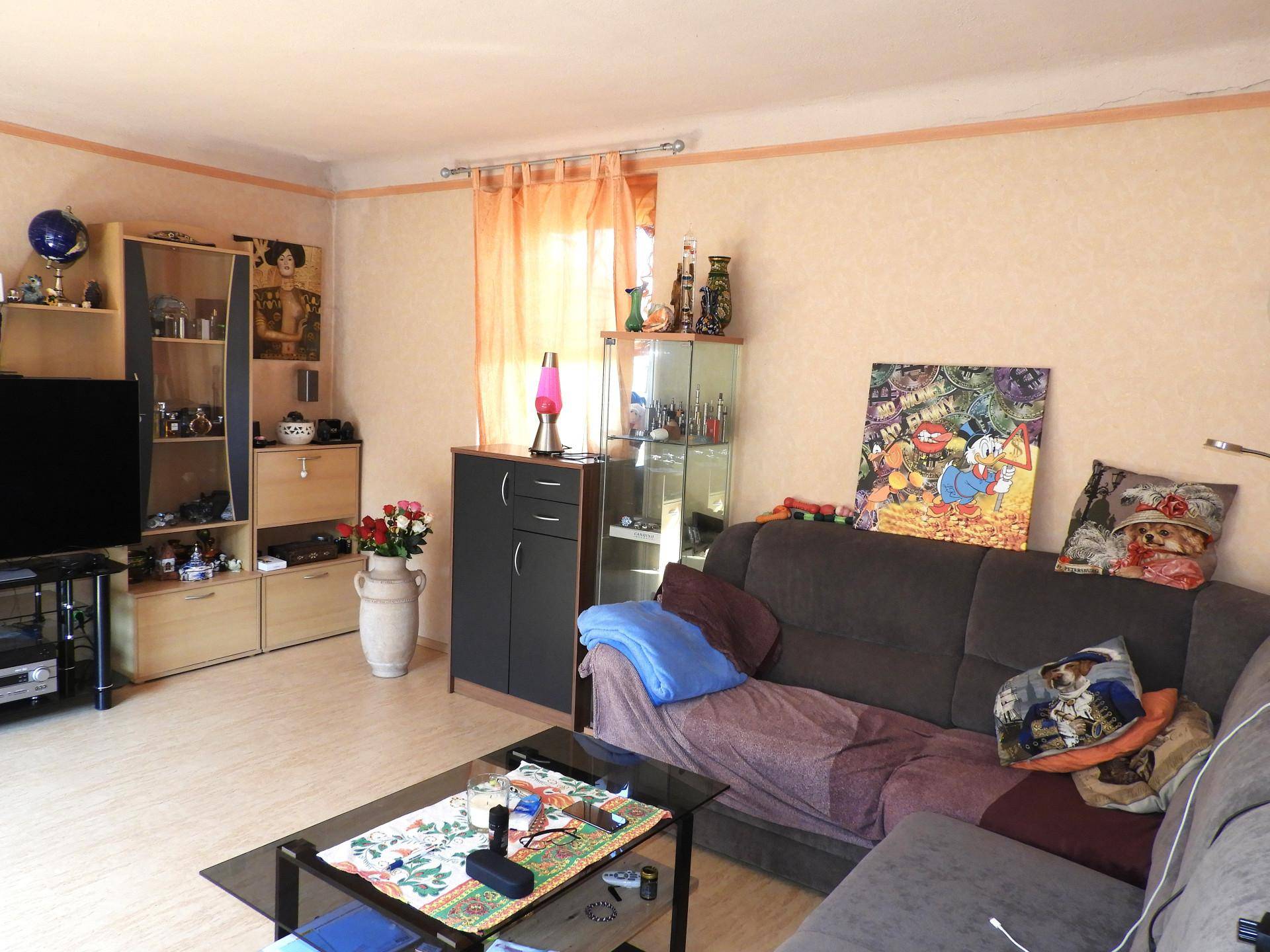 Wohnzimmer mit großem Ecksofa, Couchtisch und verschiedenen Dekorationen.