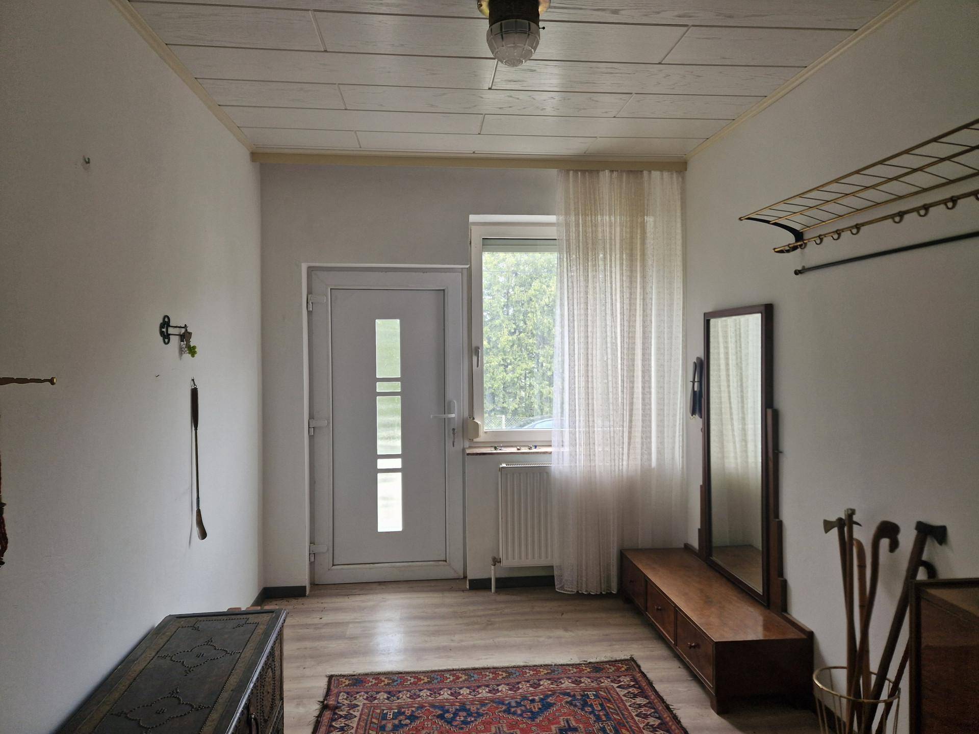 Eingangsbereich mit Garderobe, Spiegel und Fenster, bietet Zugang zum Haus.