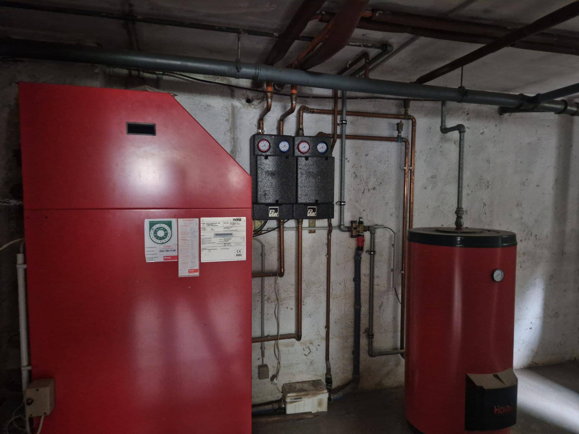 Heizungsraum im Keller mit zentraler Heizungsanlage und Warmwasserspeicher.