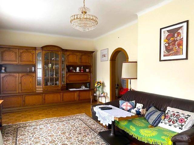 Traditionelles Wohnzimmer mit Holzmöbeln, Ledersofa und einem klassischen Kronleuchter.