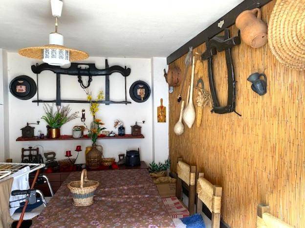 Essbereich oder Wintergarten mit langem Tisch, Stühlen und traditionellen Dekorationen.