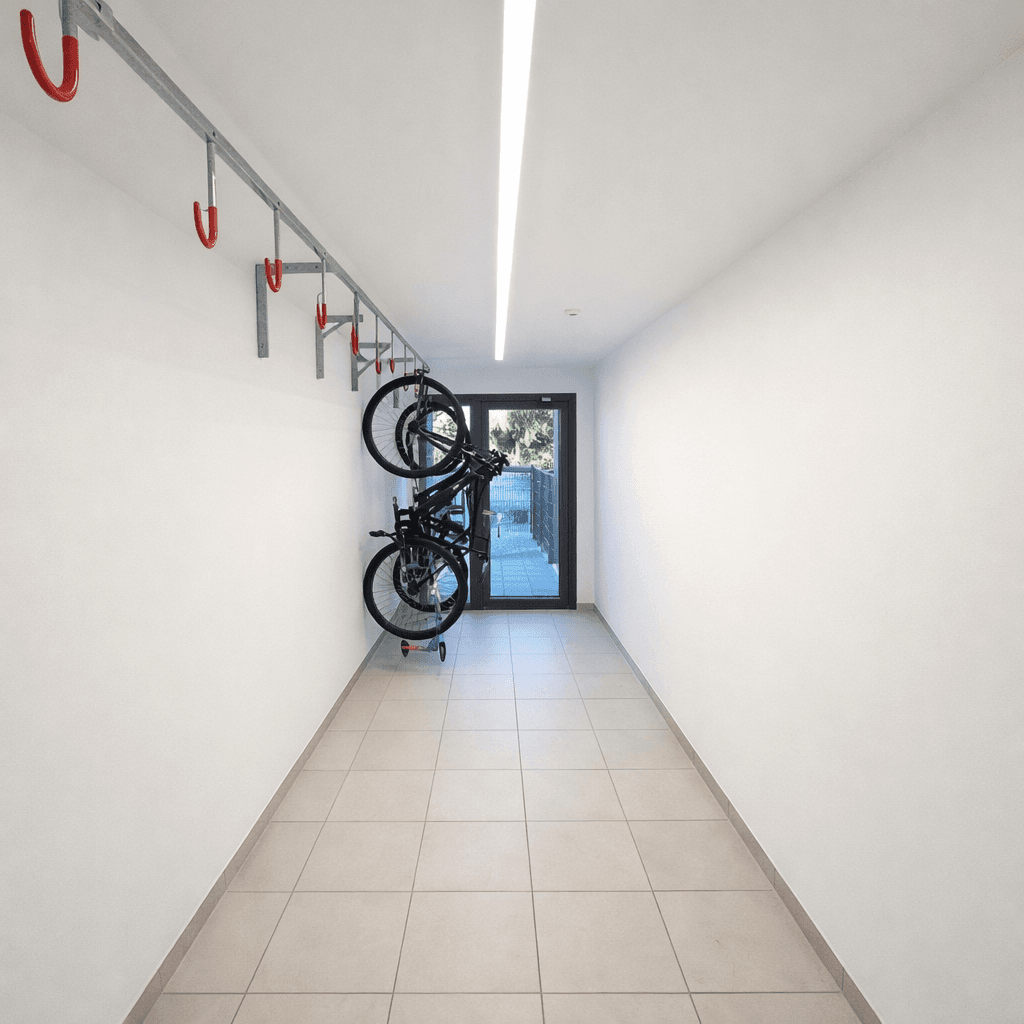 Heller Flur mit Fliesenboden und praktischen Fahrradständern an der Wand, ideal für Bewohner.