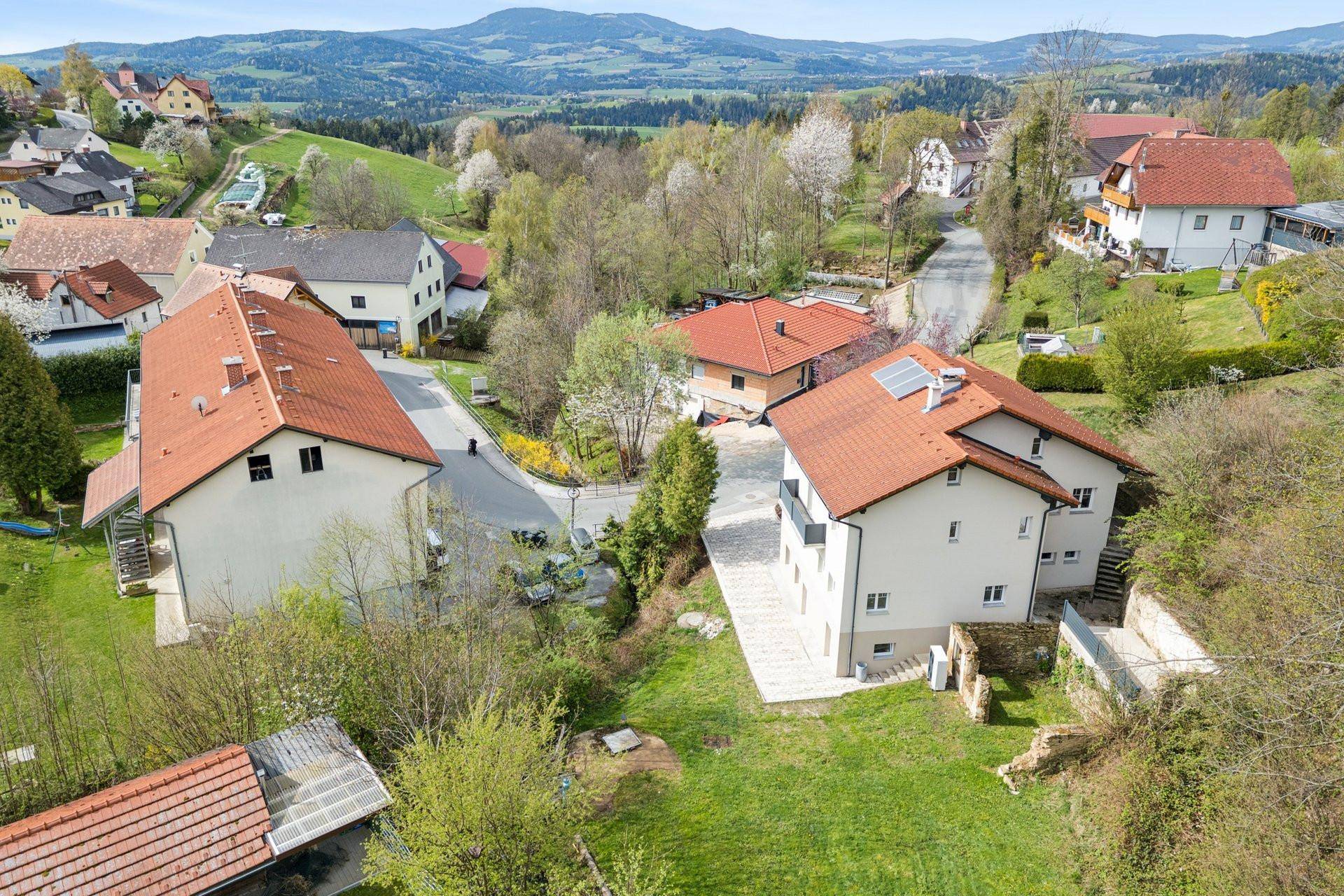 Panoramablick aus der Luft auf das Wohnhaus und die umliegende ländliche Gegend mit Bergen.