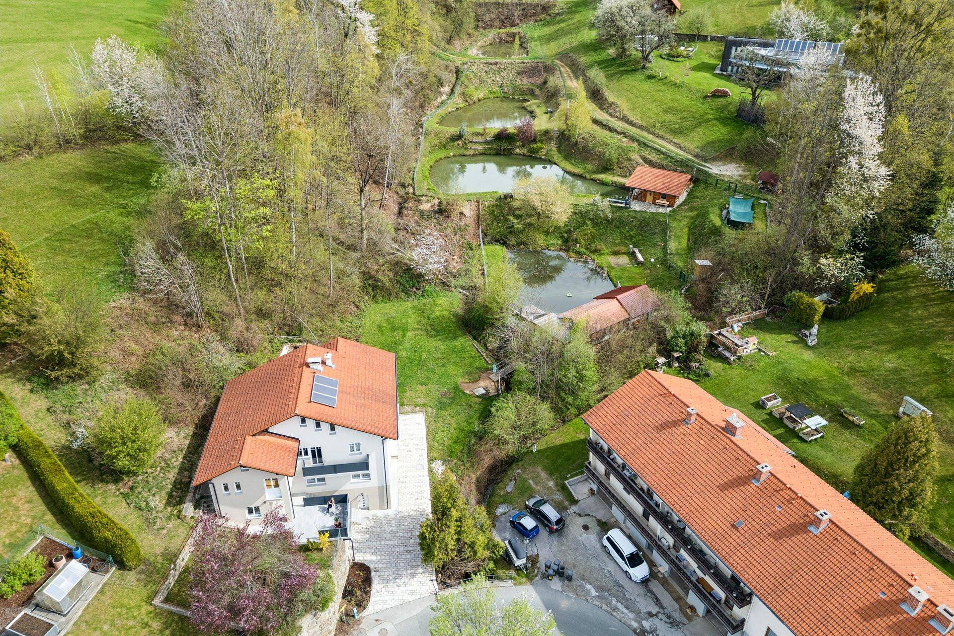 Weitläufige Luftaufnahme des Anwesens mit Teichen und viel Grün in ländlicher Umgebung.