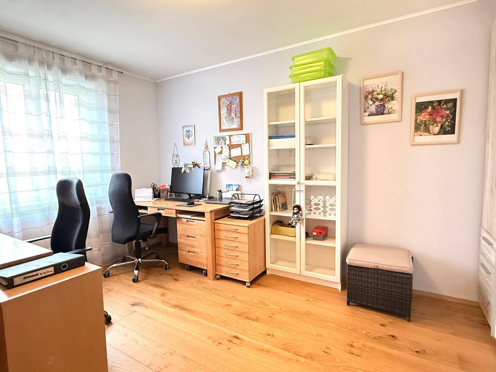 Funktionales Arbeitszimmer mit Holzschreibtisch, Bürostühlen und Regalen, ideal für Home-Office.