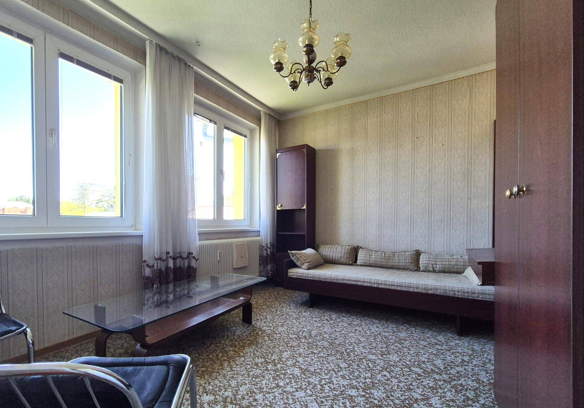 Gemütliches Wohnzimmer mit Sofa, Couchtisch und Teppichboden, ideal als Gästezimmer.