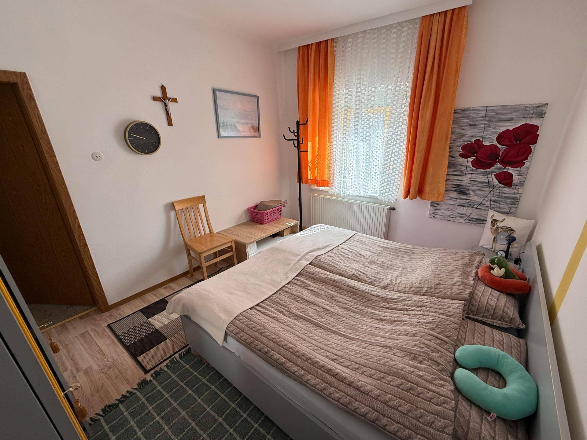 Schlafzimmer mit Doppelbett, farbigen Vorhängen und einer modernen Wandgestaltung.