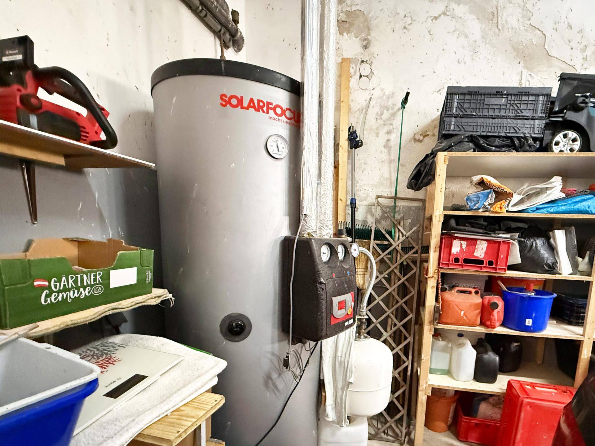 Abstellraum mit Warmwasserspeicher und Regalen für Werkzeuge und Vorräte.