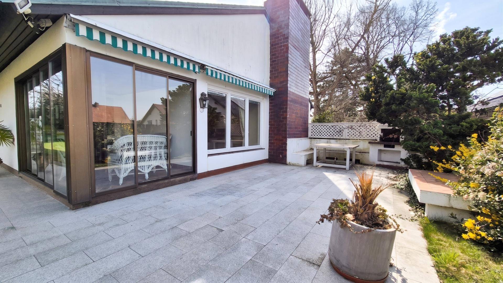 Große Terrasse mit Außenkamin und Grillbereich, ideal für gesellige Abende.