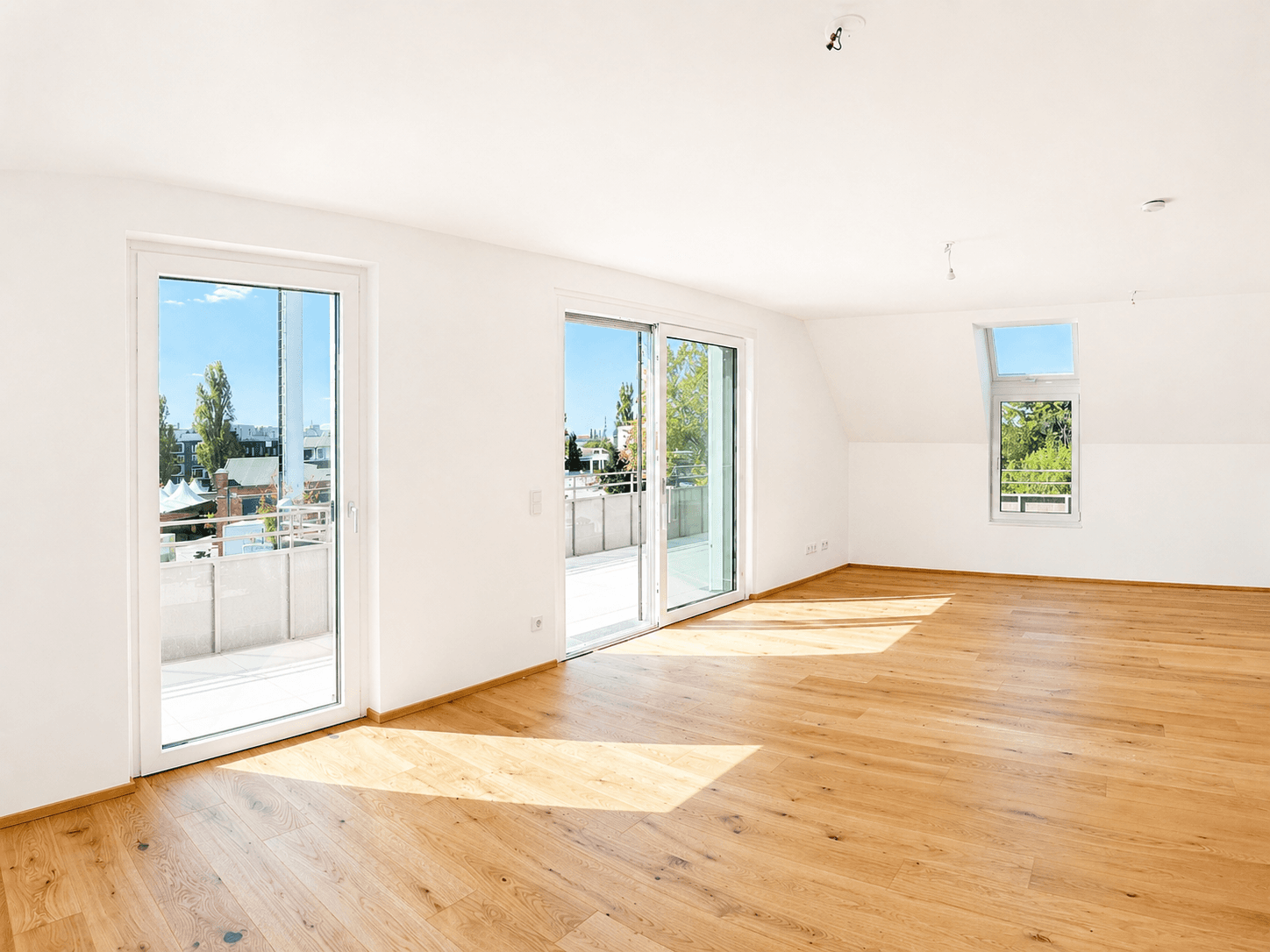 Heller Wohnraum mit Holzboden und großen Schiebetüren, die auf eine sonnige Terrasse führen.