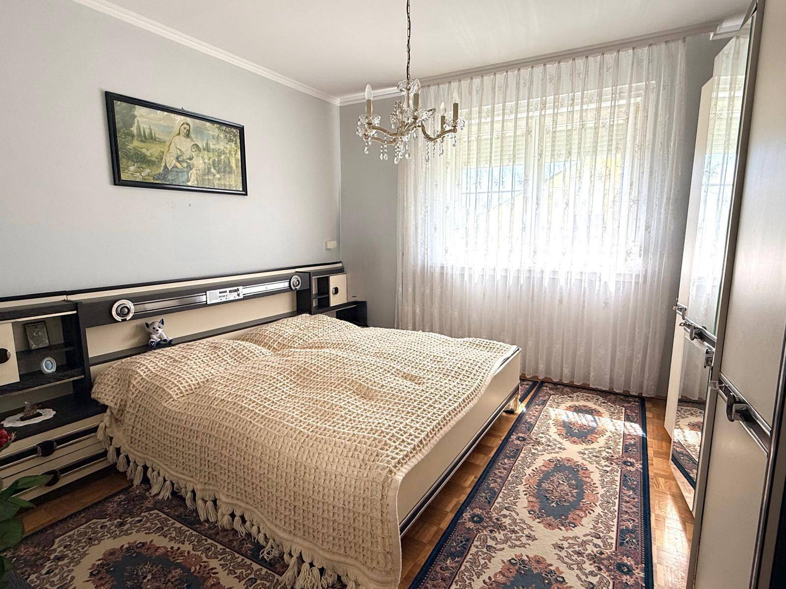 Schlafzimmer mit Doppelbett, Einbauschränken und Parkettboden.