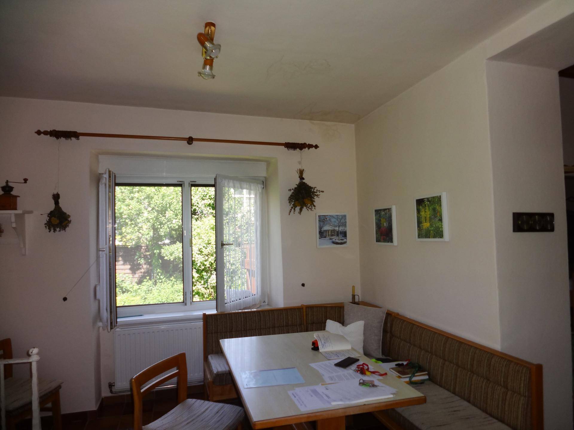 Gemütliches Wohnzimmer mit Eckbank, Esstisch und Blick in den Garten.