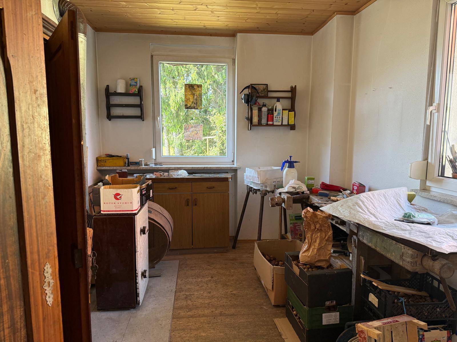 Funktionaler Raum mit Fenster, Arbeitsflächen und verschiedenen Utensilien, ideal als Werkstatt.