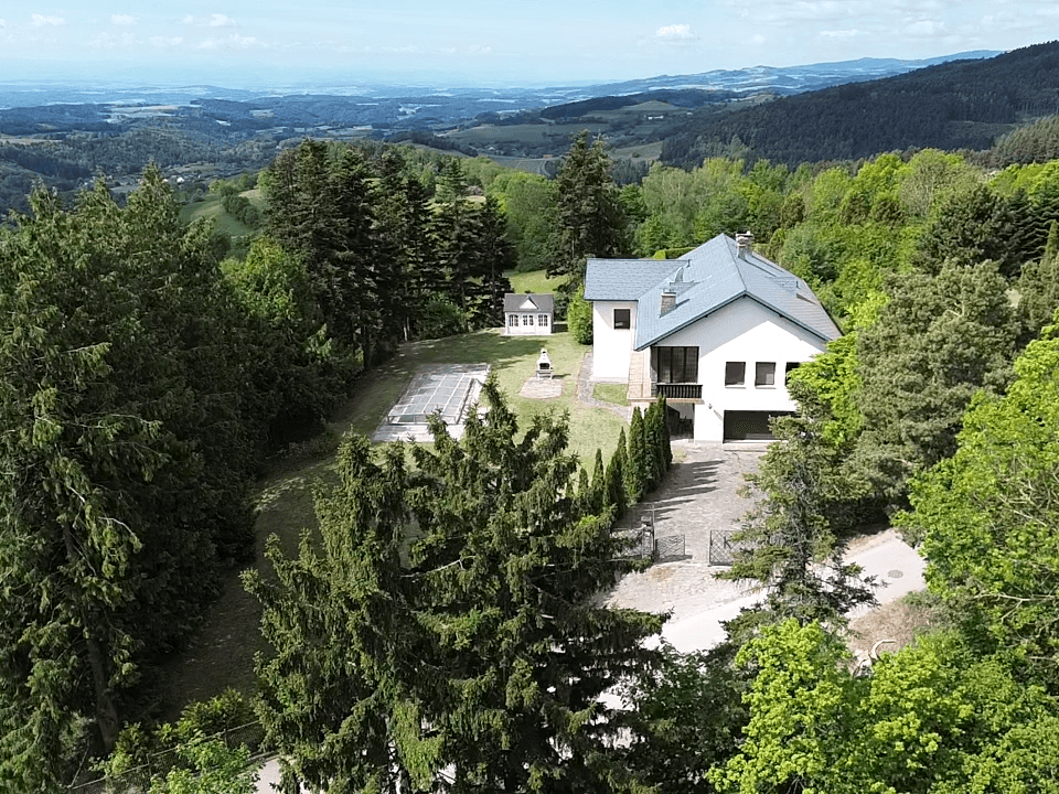 Panoramablick aus der Vogelperspektive auf das Anwesen mit Haupthaus und weitläufiger Hügellandschaft.