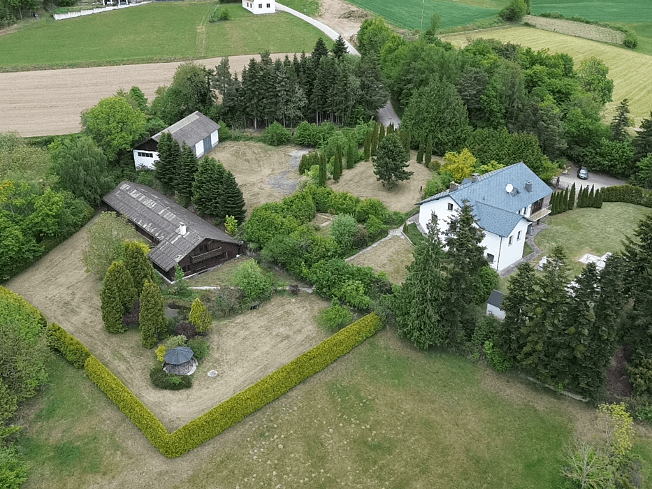 Weitläufige Luftaufnahme des Anwesens mit Haupthaus, Nebengebäuden und gepflegter Gartenanlage.