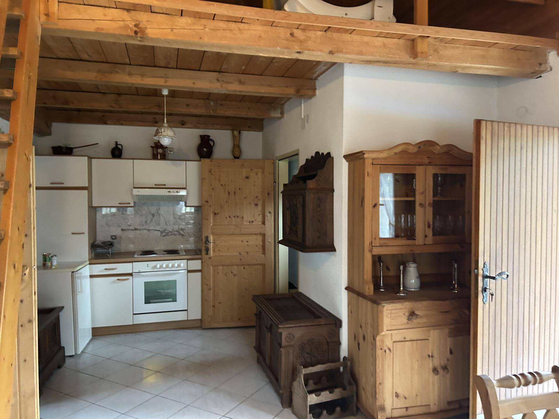 Rustikale Küche mit Holzelementen, weißen Schränken und offenem Wohnkonzept.