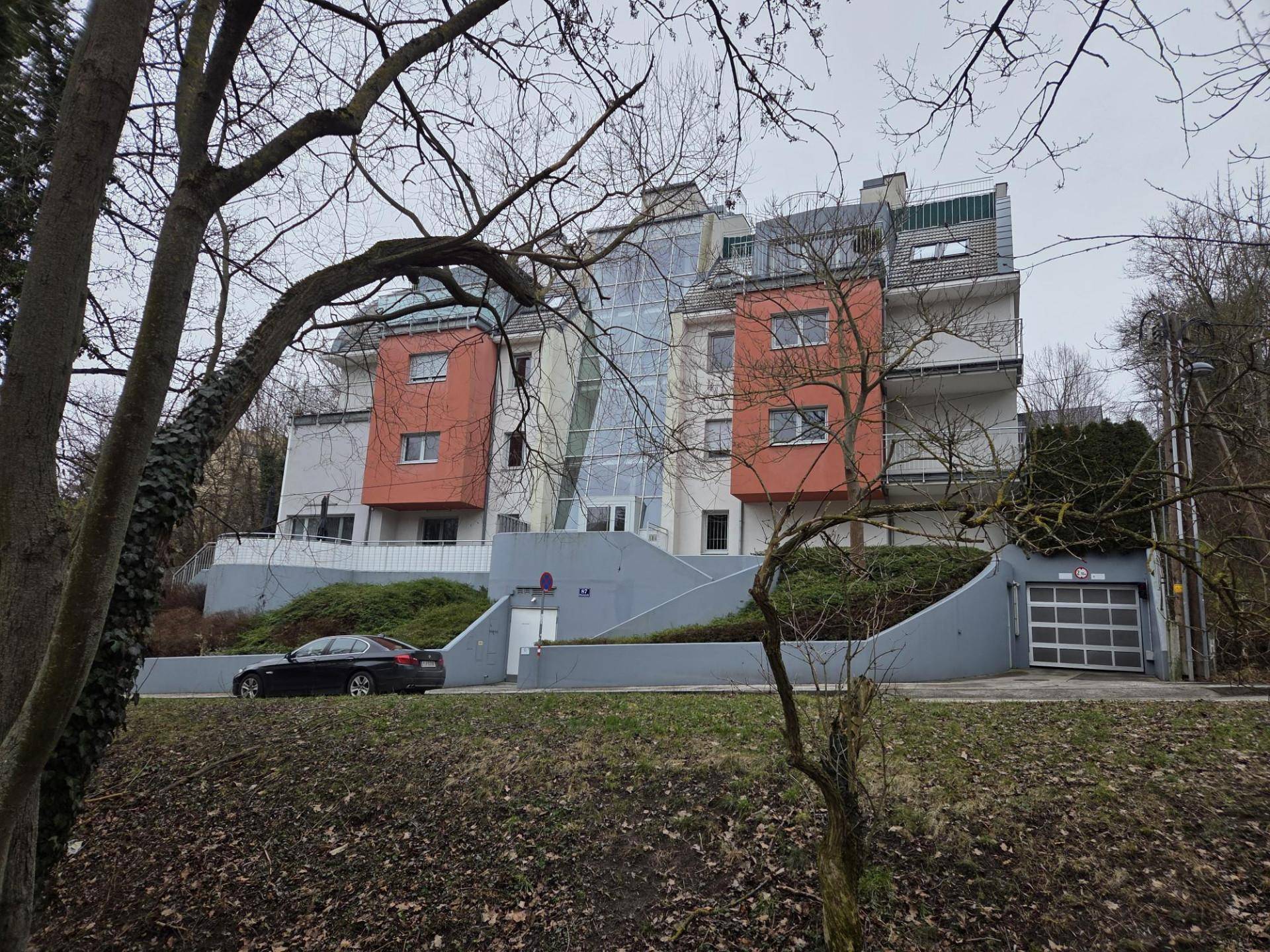 Moderne Wohnanlage mit markanter Architektur, farbigen Fassaden und viel Grün in der Umgebung.