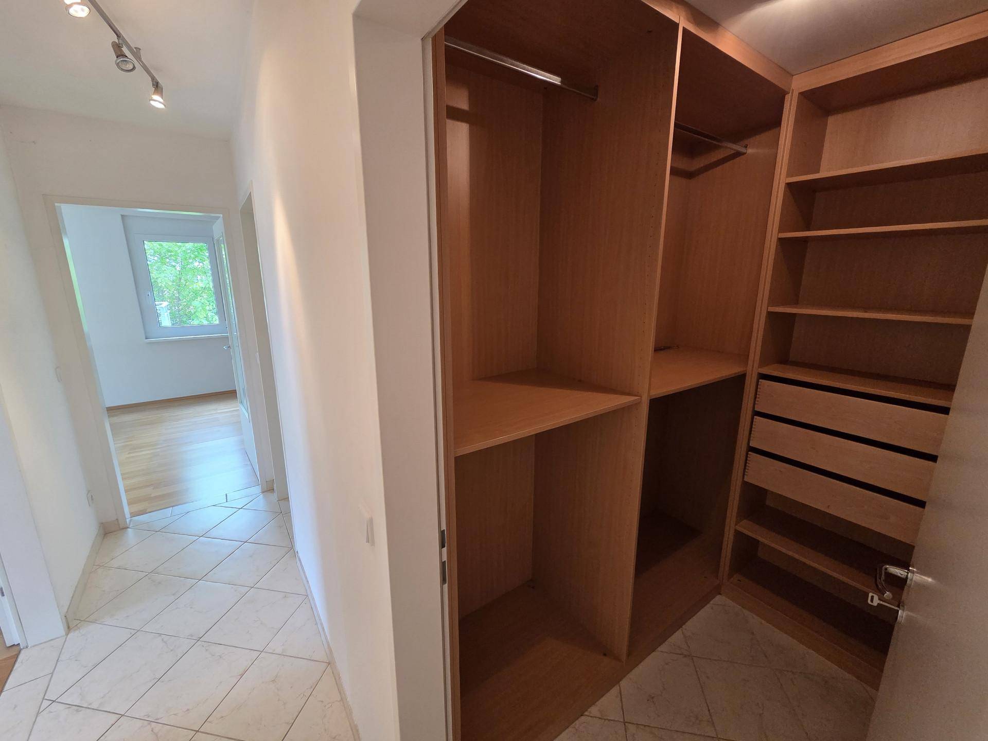 Flur mit Fliesenboden und Zugang zu einem praktischen begehbaren Kleiderschrank.
