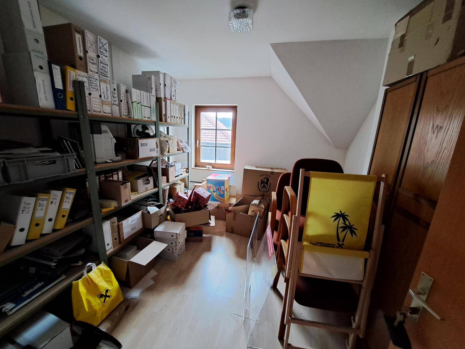 Dachgeschossraum als Abstellfläche genutzt, mit Dachschräge und Fenster für natürliches Licht.