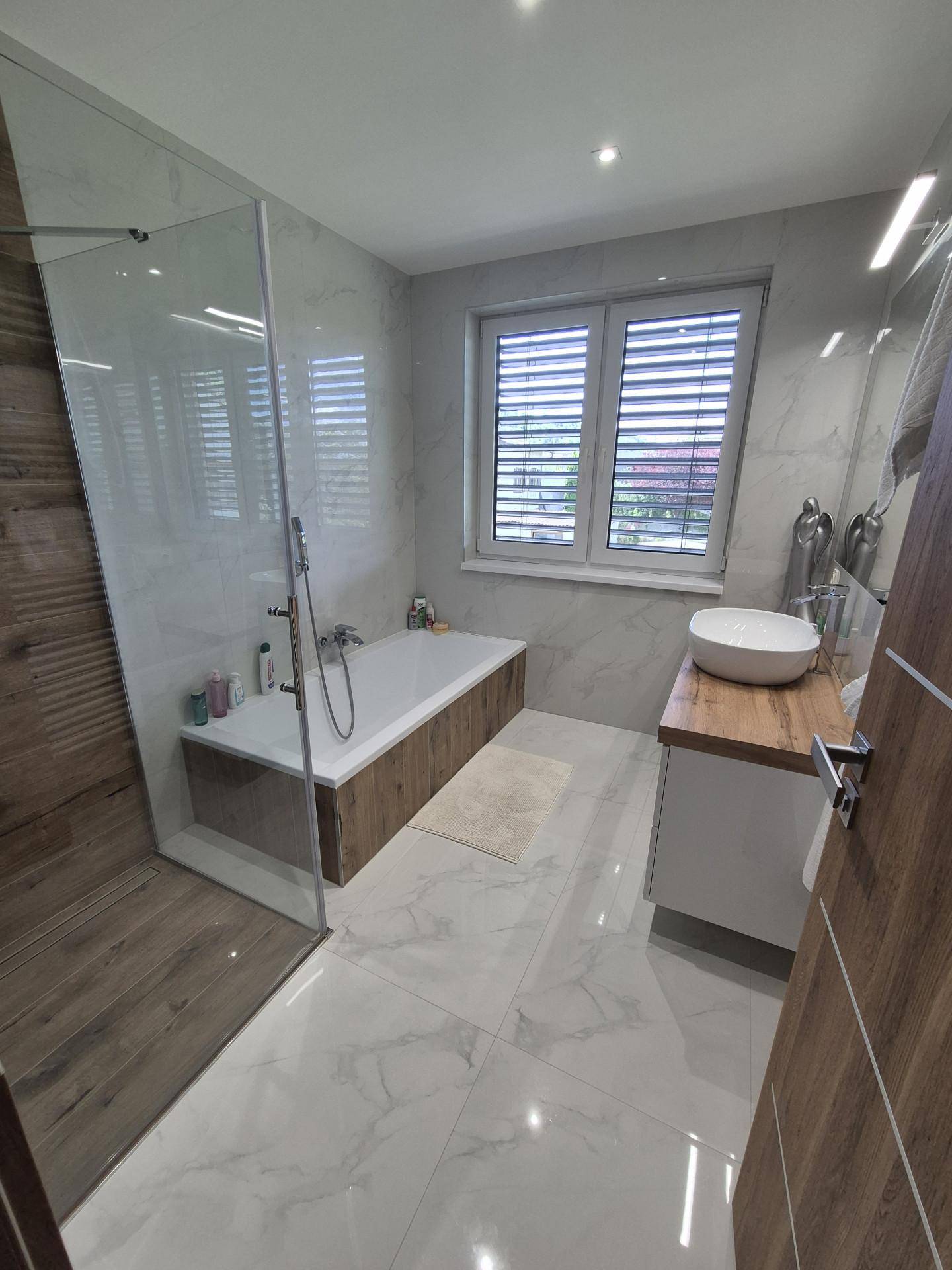 Elegantes Badezimmer mit Badewanne, begehbarer Dusche und modernem Waschtisch.