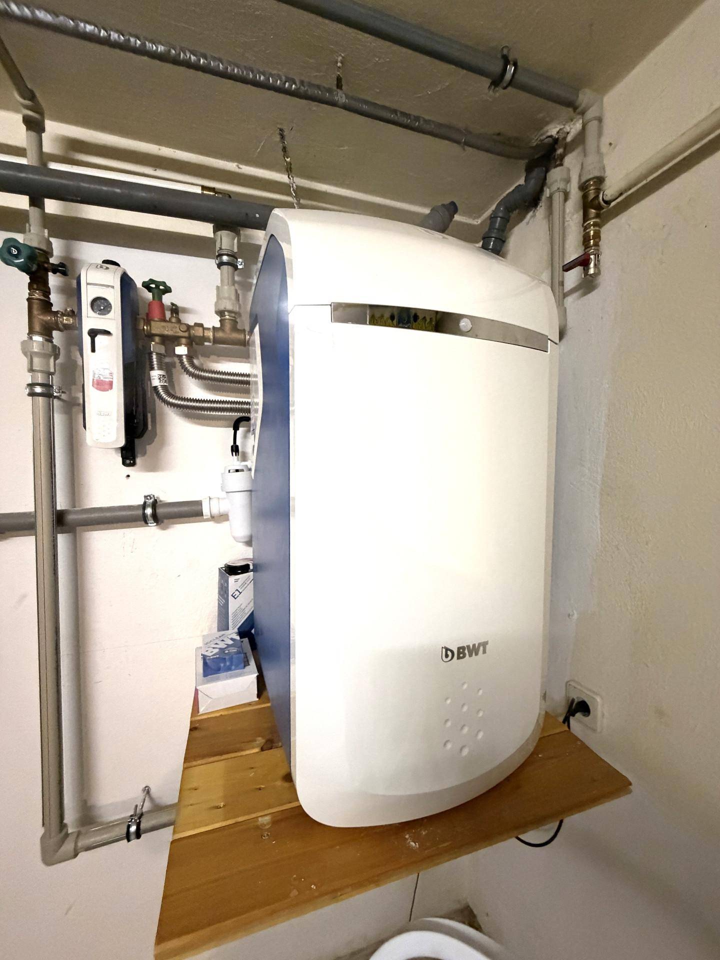 Hauswirtschaftsraum mit Wasseraufbereitungsanlage und sichtbaren Rohren.