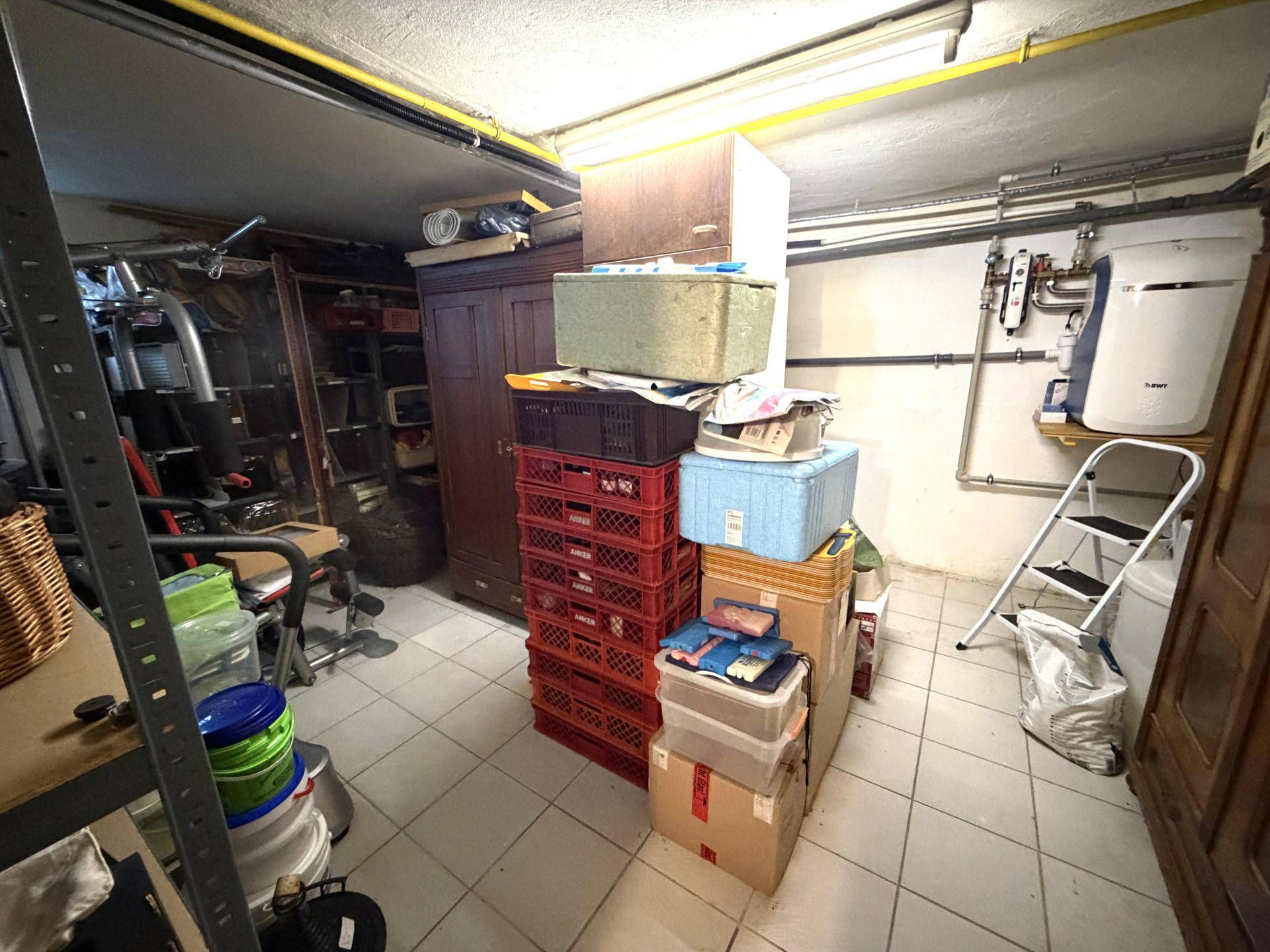 Praktischer Abstellraum im Keller mit Regalen, Schränken und vielen Lagerboxen.
