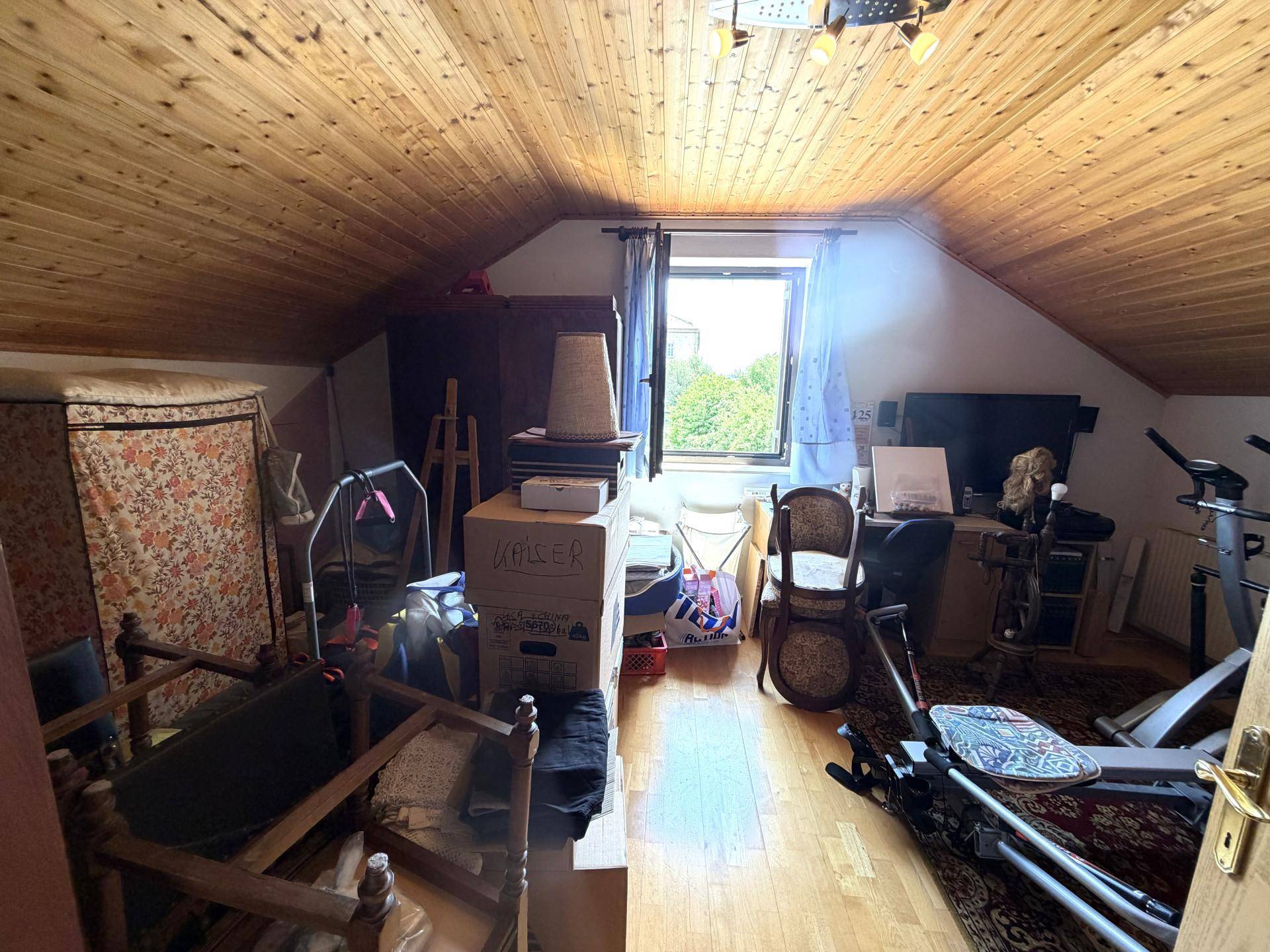 Dachboden als Abstellraum genutzt mit Holzboden, Dachschräge und Fenster.