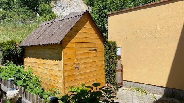 Rustikaler Holzschuppen im Gartenbereich, bietet zusätzlichen Stauraum für Gartengeräte.