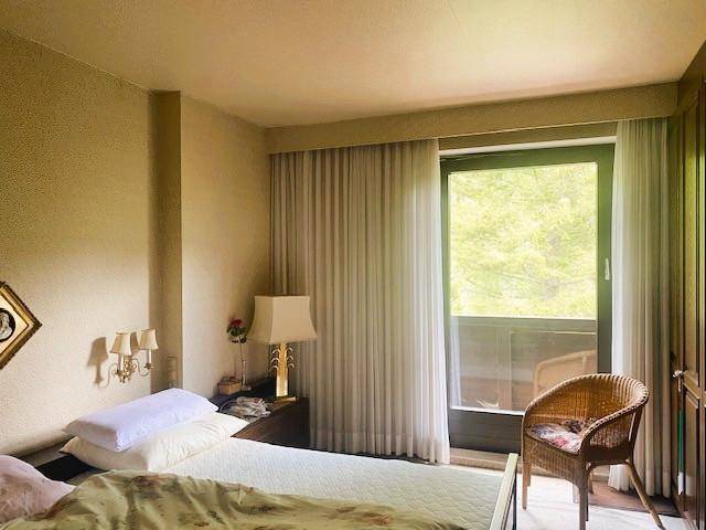 Schlafzimmer mit Doppelbett, Nachttisch und direktem Zugang zu einem Balkon.