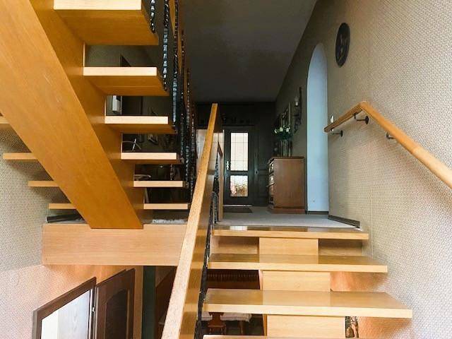 Helle Holztreppe mit Geländer, die die verschiedenen Etagen des Hauses verbindet.