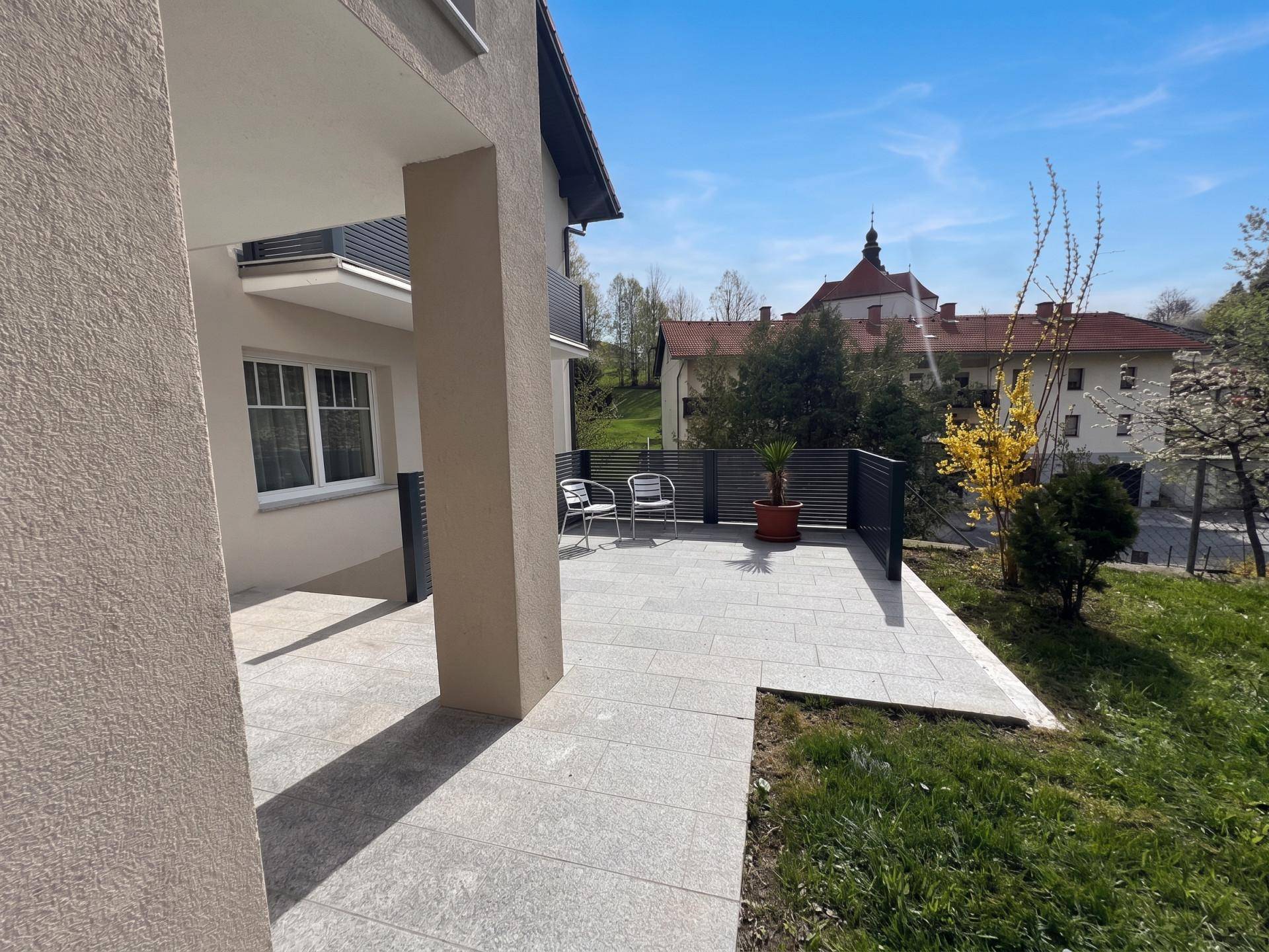 Gepflasterte Terrasse mit Sitzgelegenheiten und Blick auf die umliegende Bebauung.