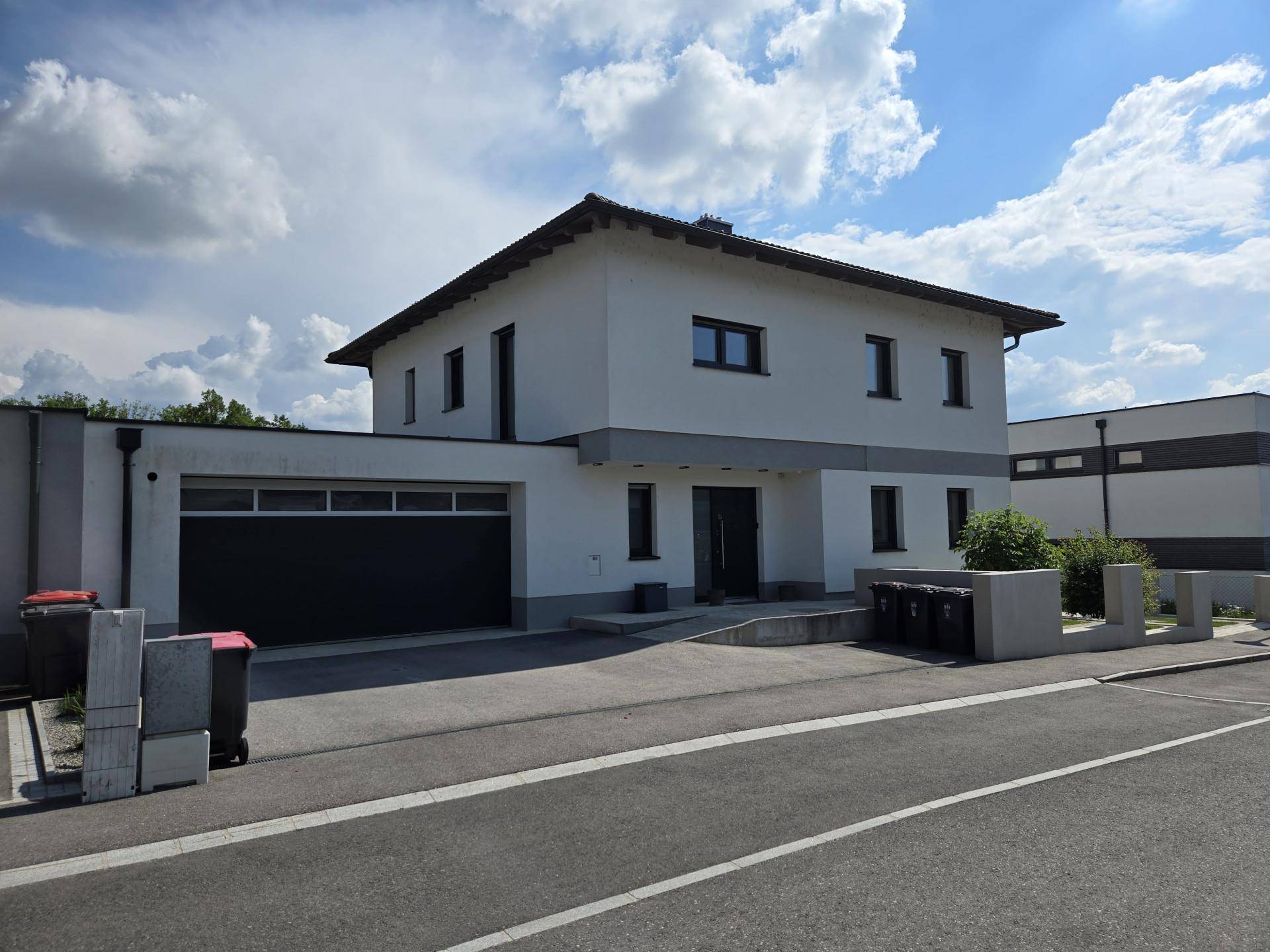 Vorderansicht des modernen Einfamilienhauses mit Doppelgarage und gepflegtem Eingangsbereich.
