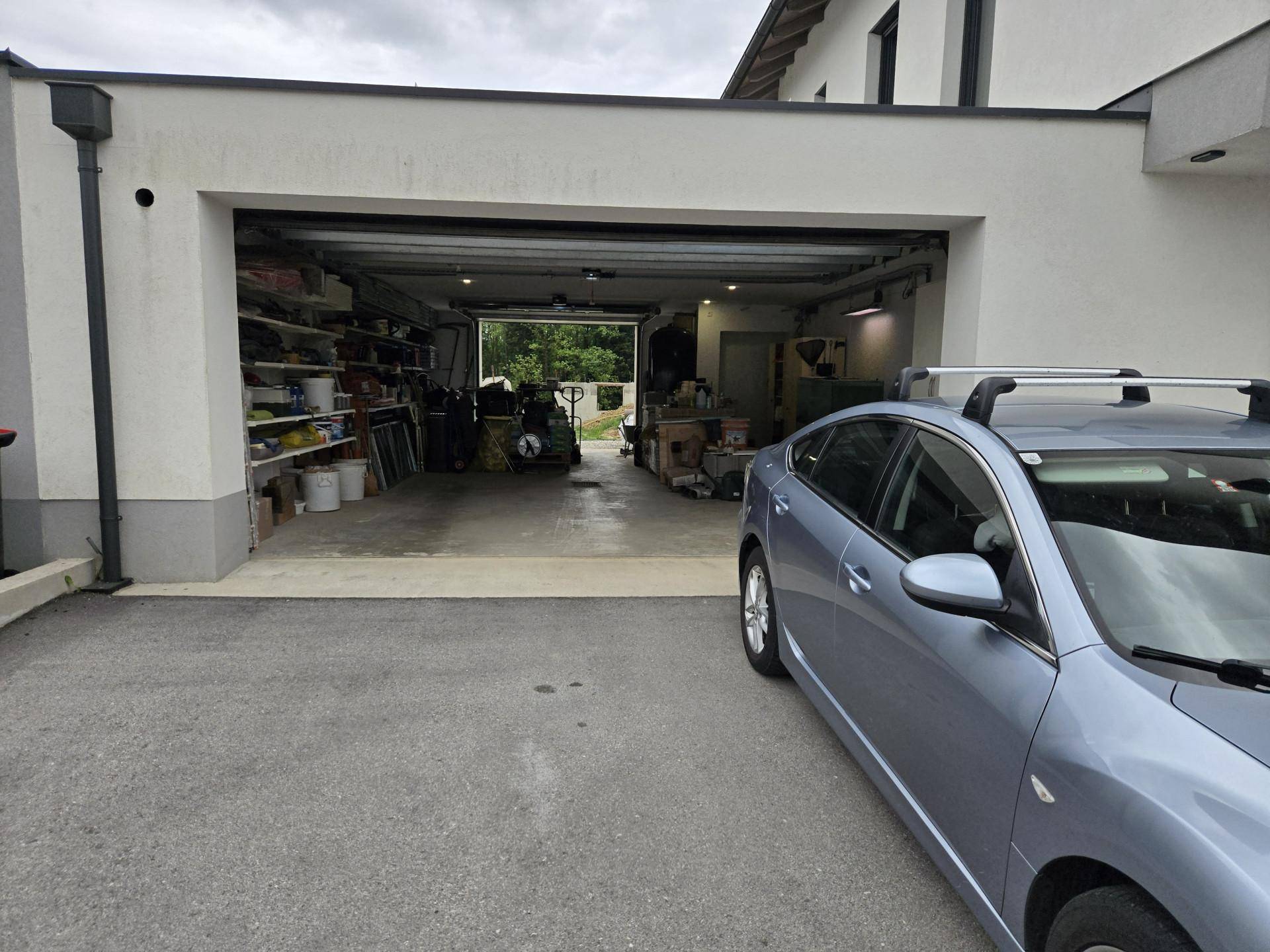 Geräumige Garage mit viel Stauraum und Regalen, die auch als Werkstatt genutzt werden kann.
