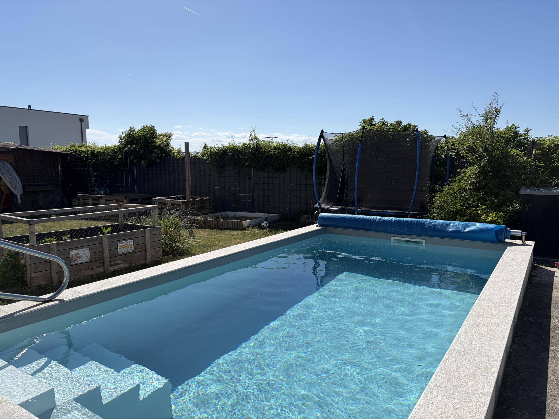 Blauer Swimmingpool im Garten mit Treppeneinstieg und umgebender Rasenfläche.