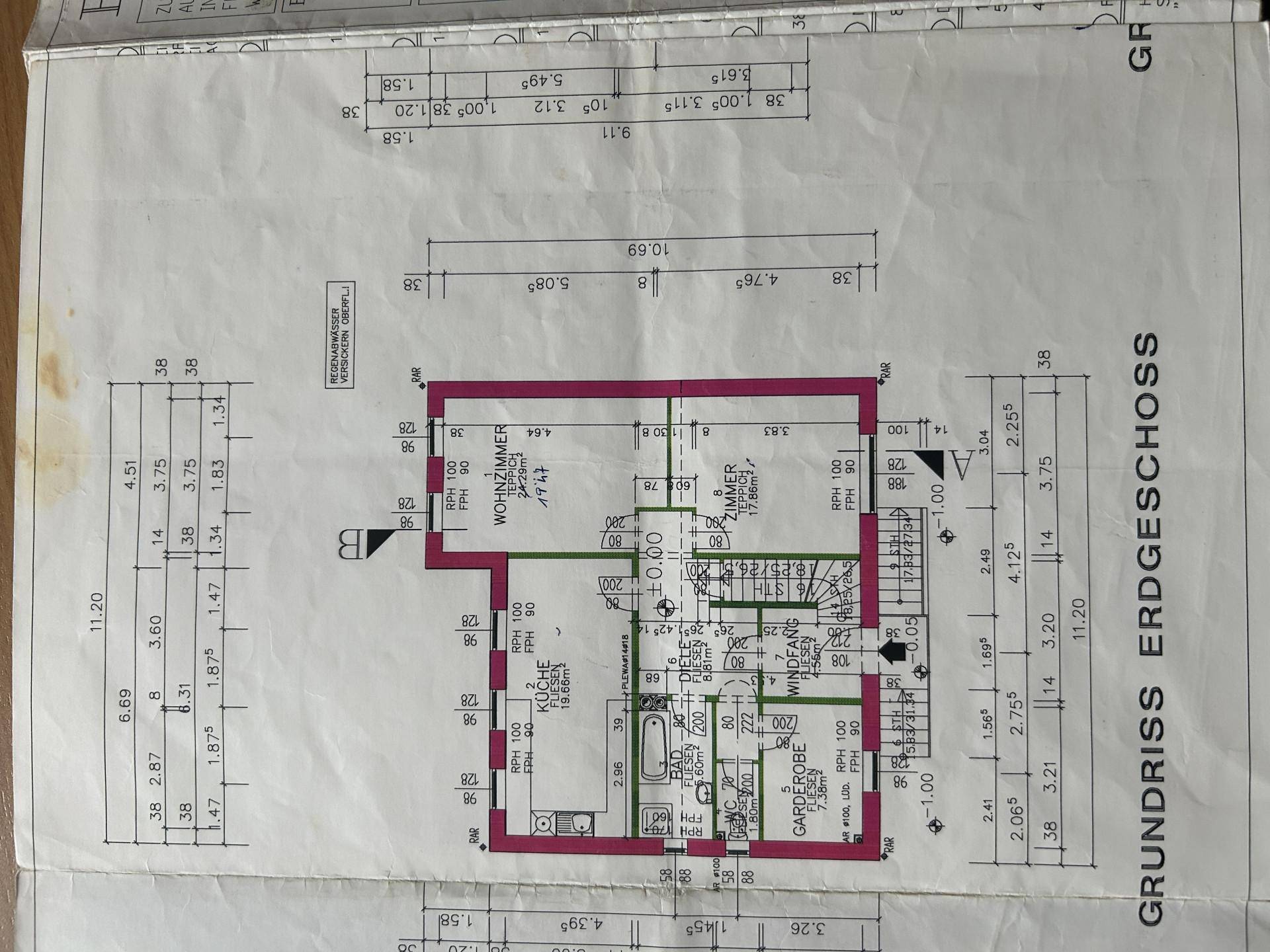 Grundriss des Erdgeschosses mit Küche, Wohnzimmer und Badezimmer.