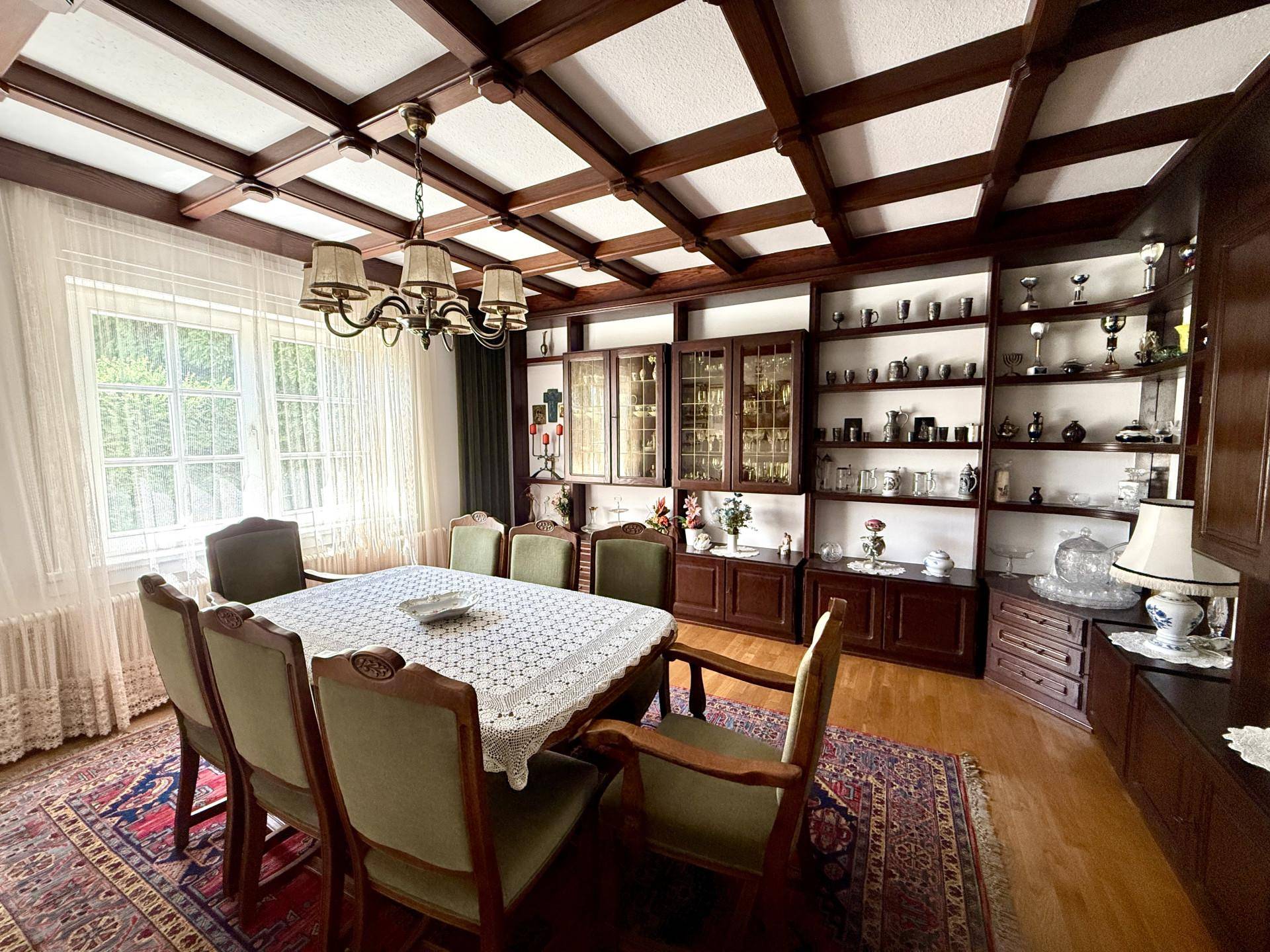 Geräumiges Esszimmer mit Holzbalkendecke, großem Esstisch und traditionellen Möbeln.