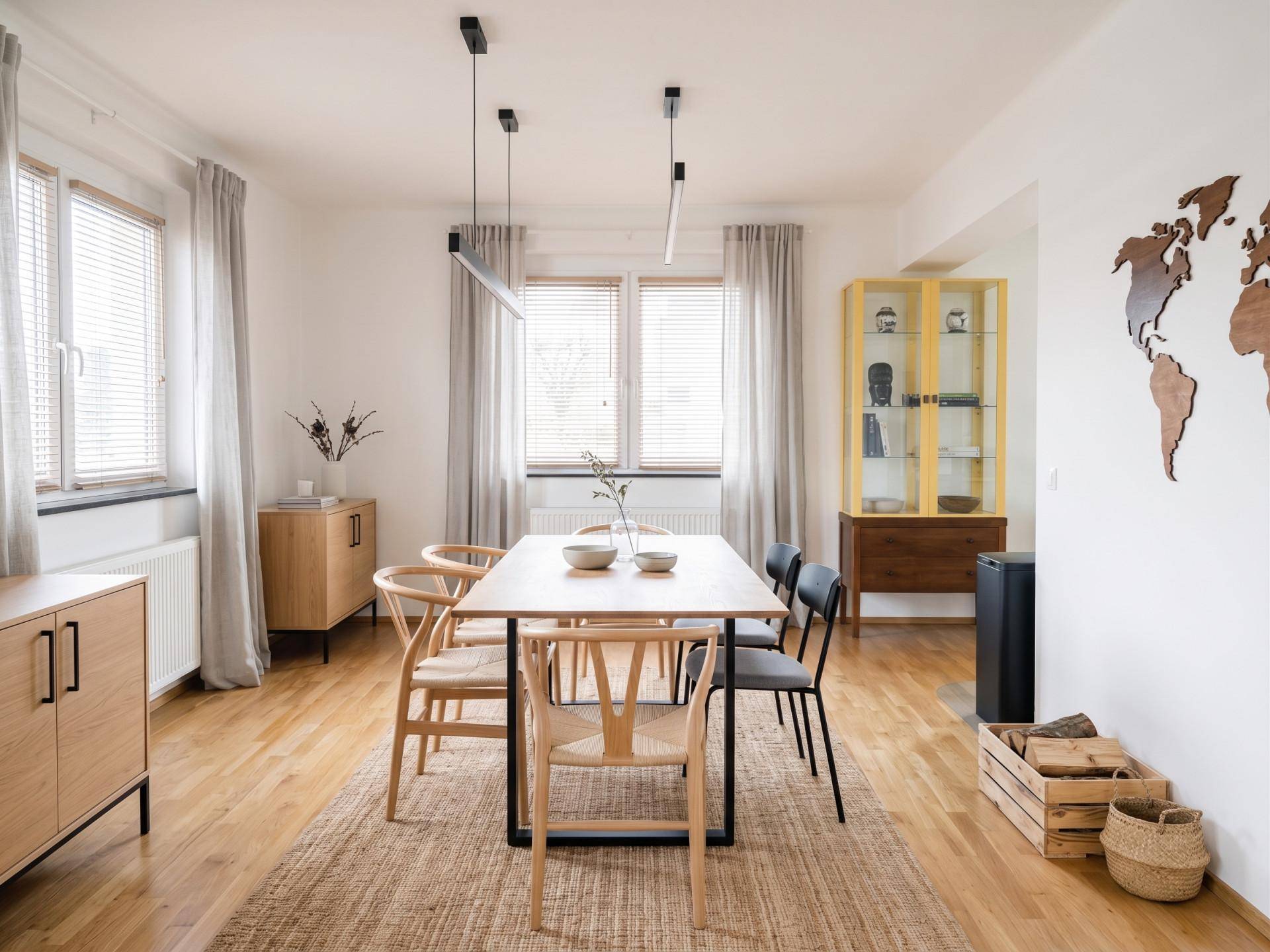 Heller Essbereich mit Holzboden, modernem Esstisch und stilvollen Holzstühlen.