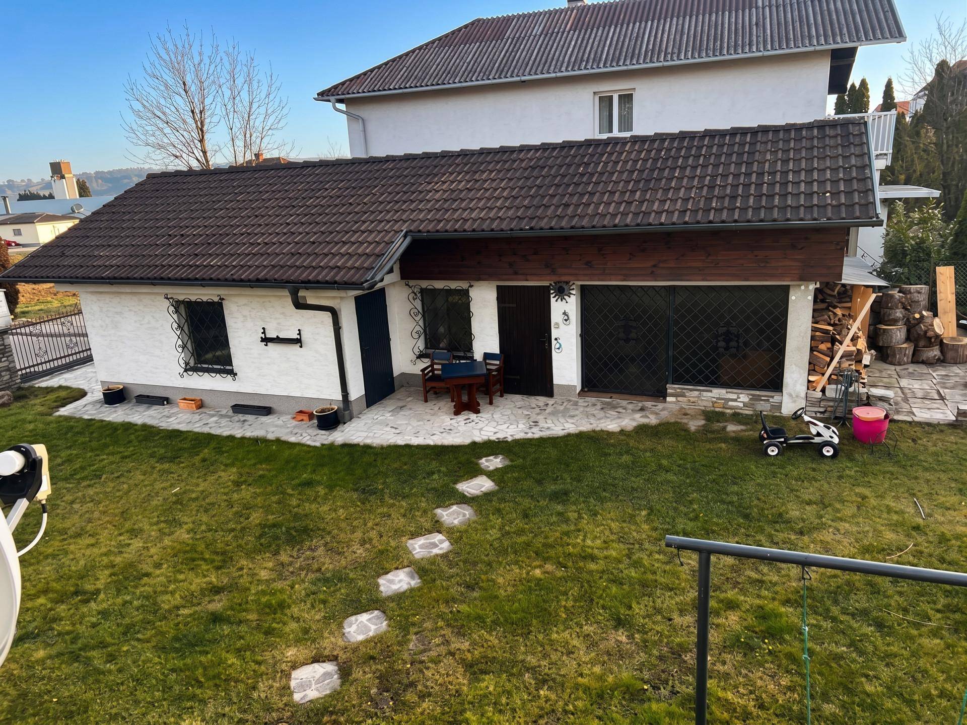 Nebengebäude mit Garage und Gartenbereich, gepflegt und funktional gestaltet.