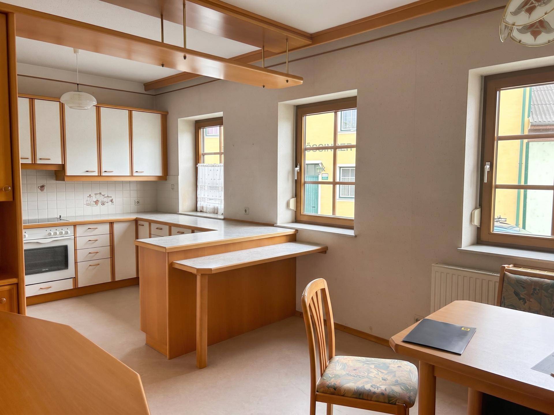 Geräumige Küche mit Essbereich, U-förmiger Arbeitsplatte und Holzmöbeln, bietet viel Platz.