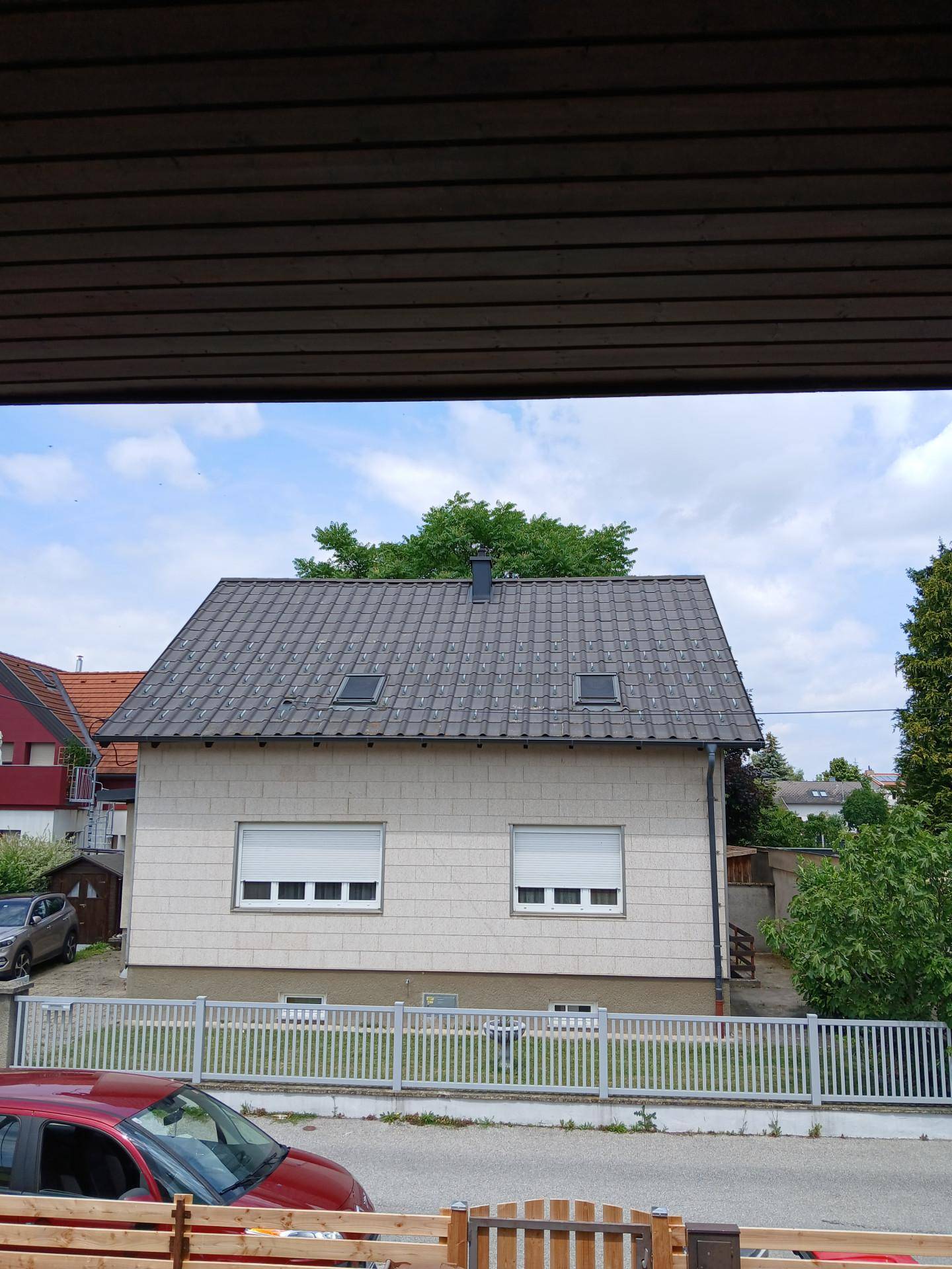 Vorderansicht des Hauses mit Satteldach, Dachfenstern und geschlossenen Rollläden an den Fenstern.
