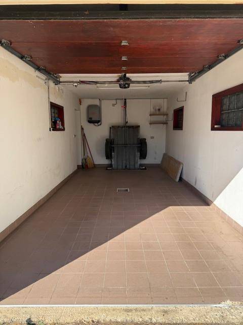 Geräumige Garage mit Fliesenboden und ausreichend Platz für ein Fahrzeug.